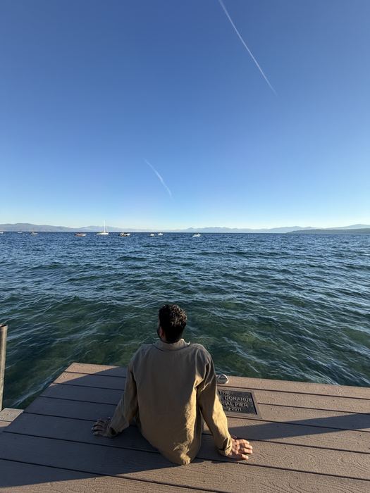 Naveen sitting on a pier looking out over Lake Tahoe