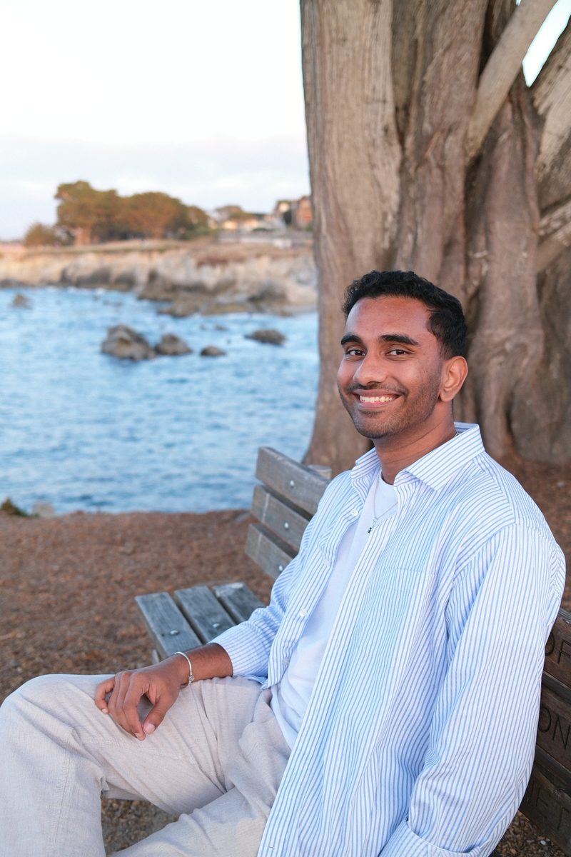 Naveen Kumar Rajesh on a bench by the ocean